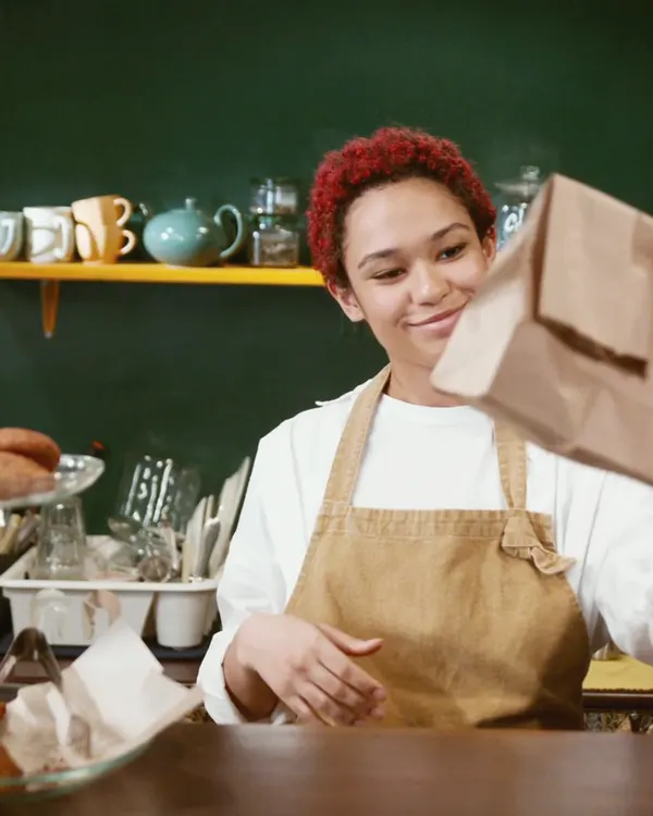 Une commerçante sert des viennoiseries au comptoir